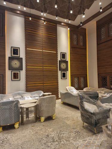 Photograph of a Meethaq Hotel interior lounge with wood-panelled walls and decorative lighting.